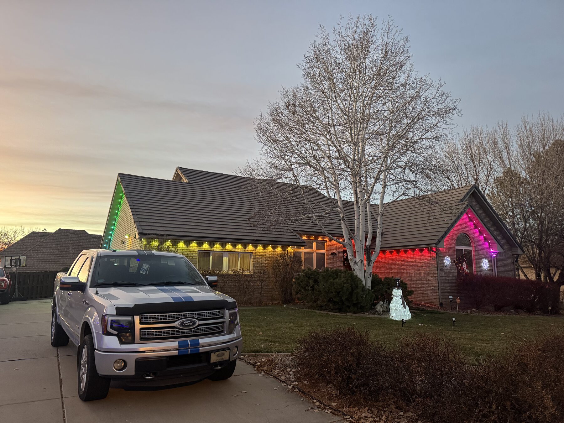Warm white permanent lighting across a home roofline
